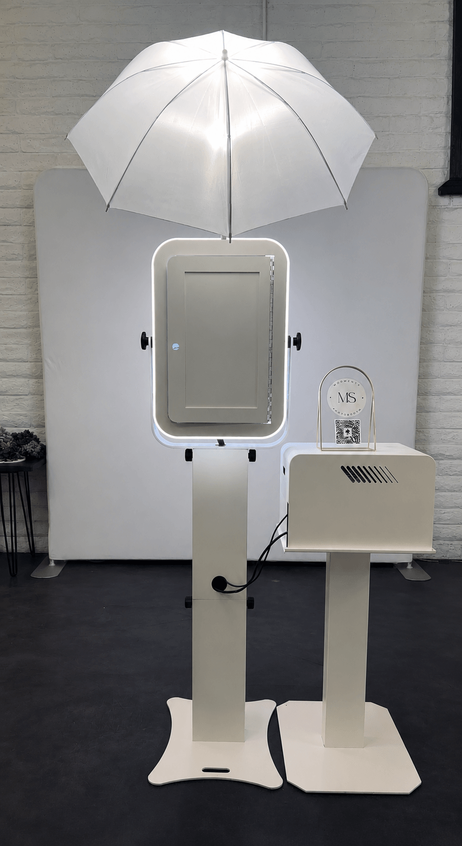 A white umbrella-shaped light fixture above a rectangular mirror and a small machine on a stand, set against a white background.