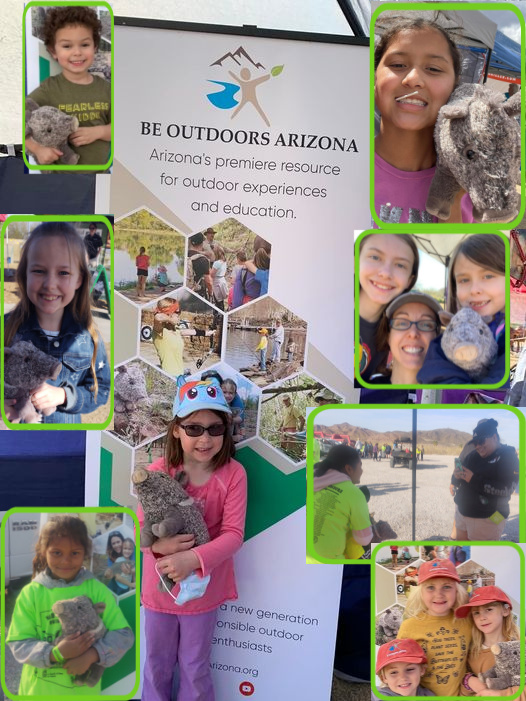 Group of children and adults outdoors with a sign reading 'Be Outdoors Arizona,' some holding animals, in bright clothing, sunny day.