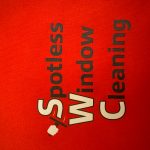 Red background with black and white text reading 'Spotless Window Cleaning' and a squeegee icon.