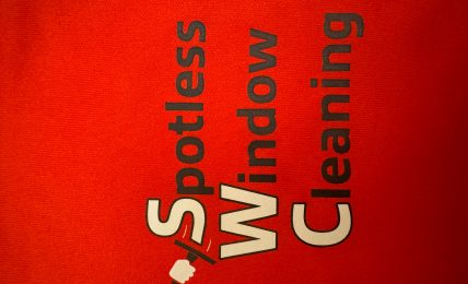Red background with black and white text reading 'Spotless Window Cleaning' and a squeegee icon.