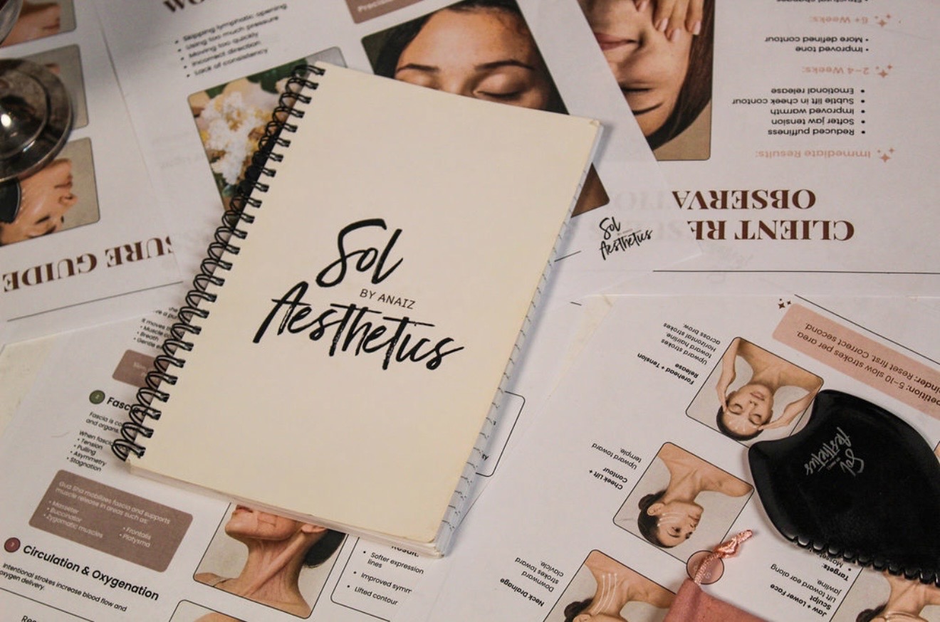 Open notebook with handwritten text 'Sol Aesthetics' surrounded by skincare and beauty product brochures