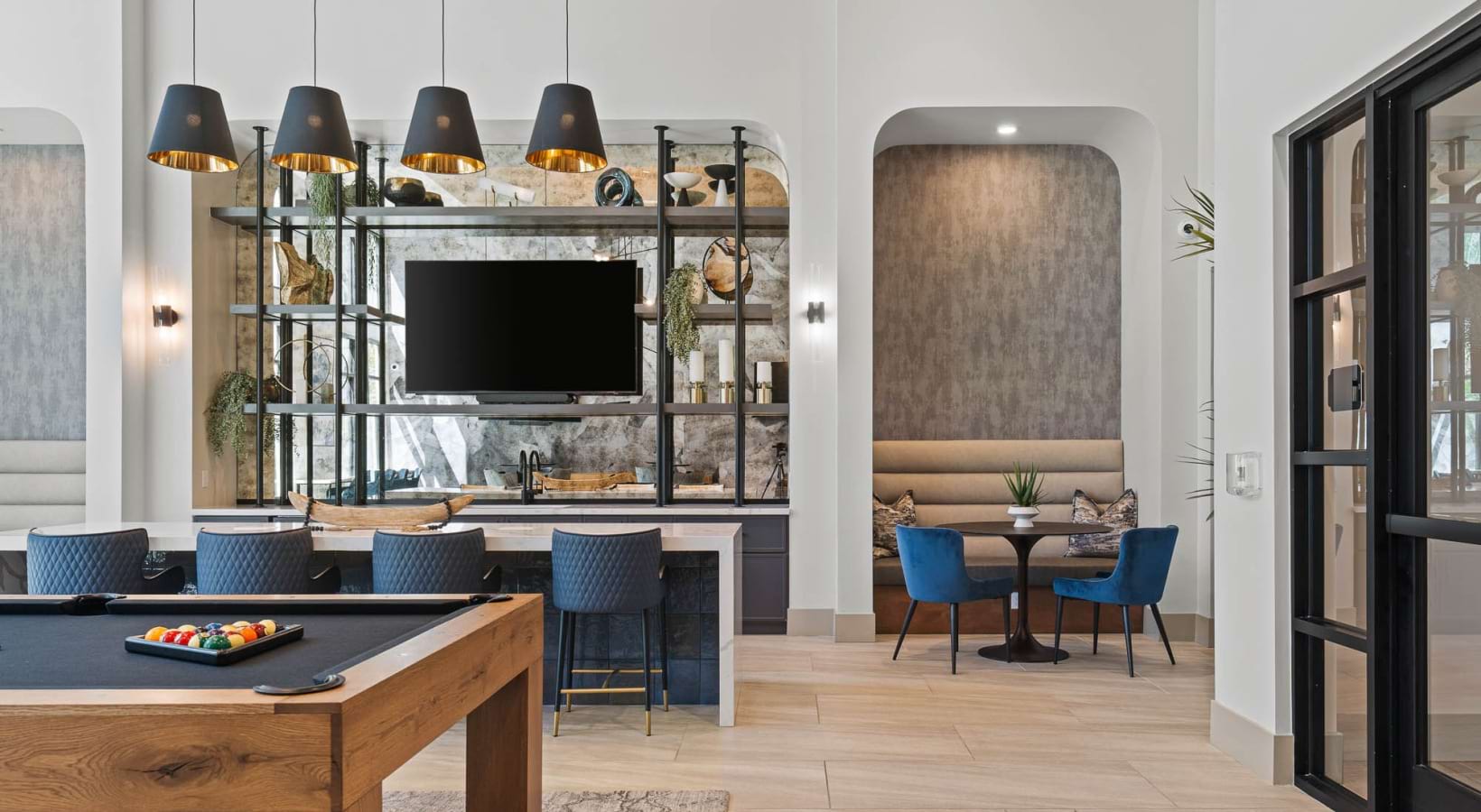 Modern interior with a TV, shelves, and seating area, featuring a wooden table and large window, bright and stylish.